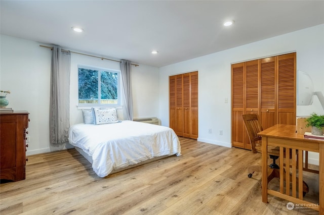 bedroom with two closets and light wood-type flooring