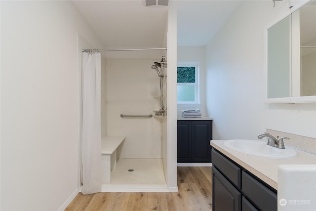 bathroom with a shower with shower curtain, hardwood / wood-style floors, and vanity