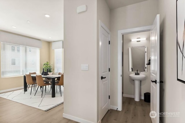 hallway with light hardwood / wood-style floors and sink