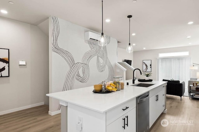 kitchen featuring white cabinets, light hardwood / wood-style flooring, sink, and an island with sink