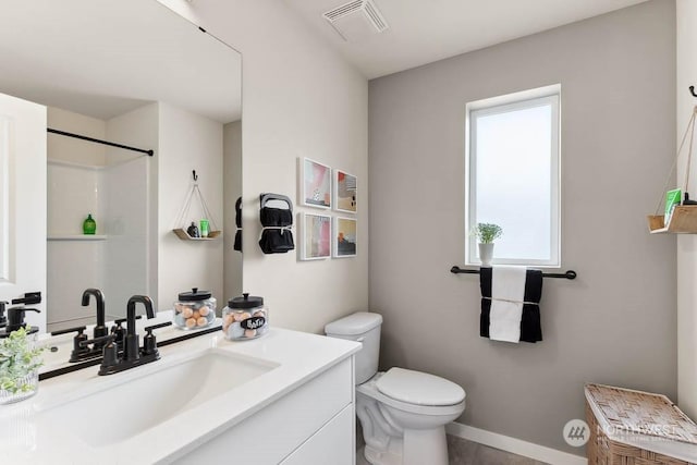 bathroom featuring a shower, vanity, and toilet