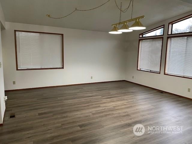 spare room featuring dark hardwood / wood-style floors and lofted ceiling