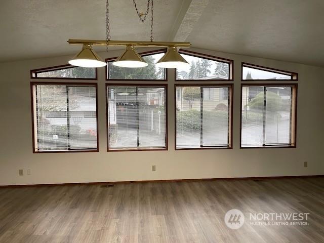 interior space with hardwood / wood-style floors and vaulted ceiling