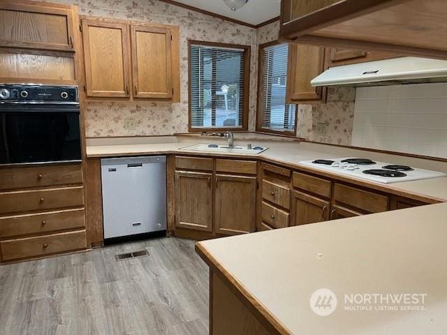 kitchen featuring stainless steel dishwasher, white gas cooktop, light hardwood / wood-style flooring, oven, and lofted ceiling