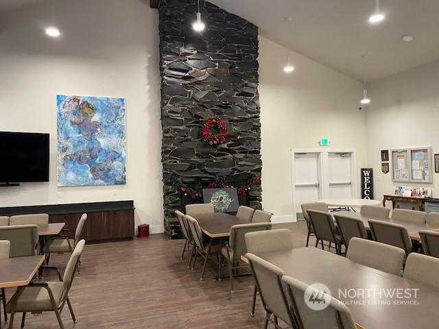 dining space with dark hardwood / wood-style floors and high vaulted ceiling