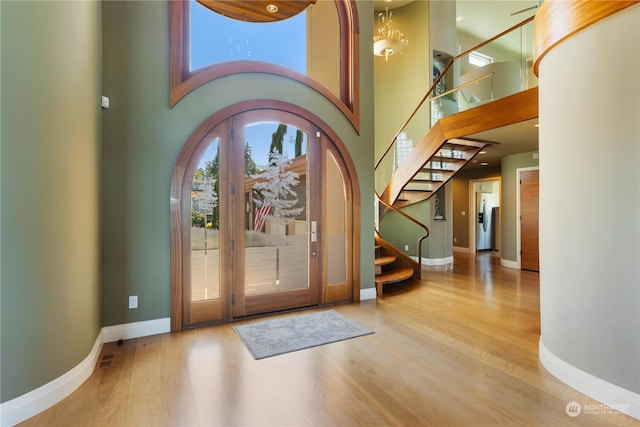 entryway featuring a towering ceiling and hardwood / wood-style flooring