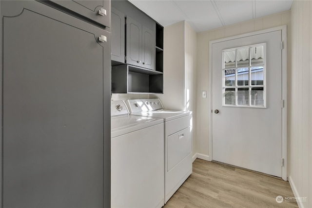 laundry area with washer and dryer, cabinets, and light hardwood / wood-style floors