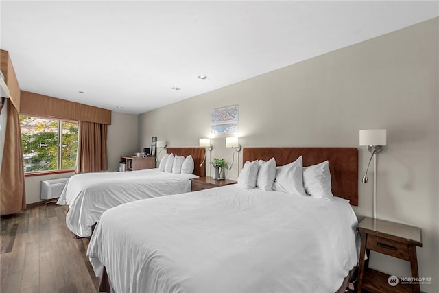 bedroom featuring a wall mounted air conditioner and dark wood-type flooring