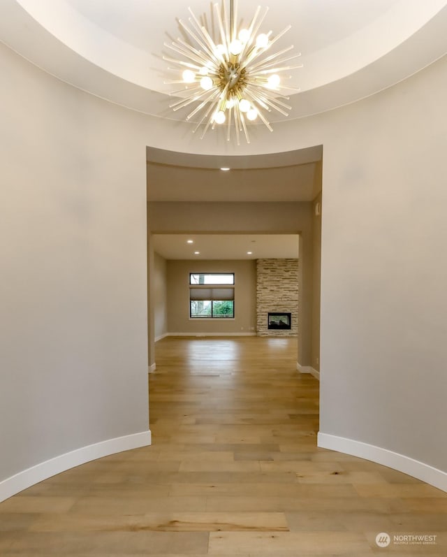 interior space with a fireplace, light hardwood / wood-style floors, and a notable chandelier