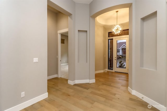 hallway featuring a notable chandelier and light hardwood / wood-style flooring