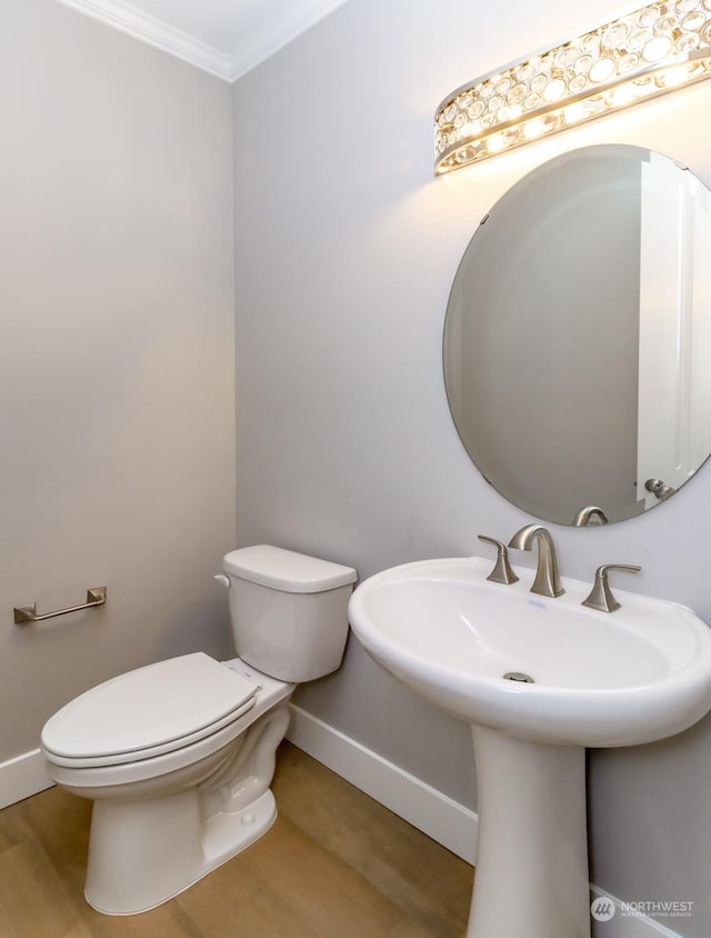 bathroom featuring wood-type flooring, toilet, and ornamental molding