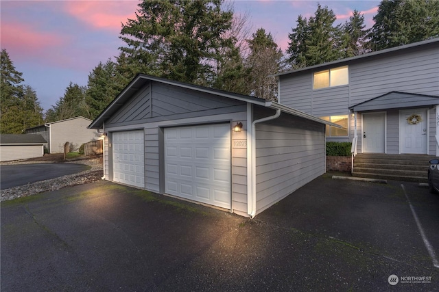 view of garage at dusk