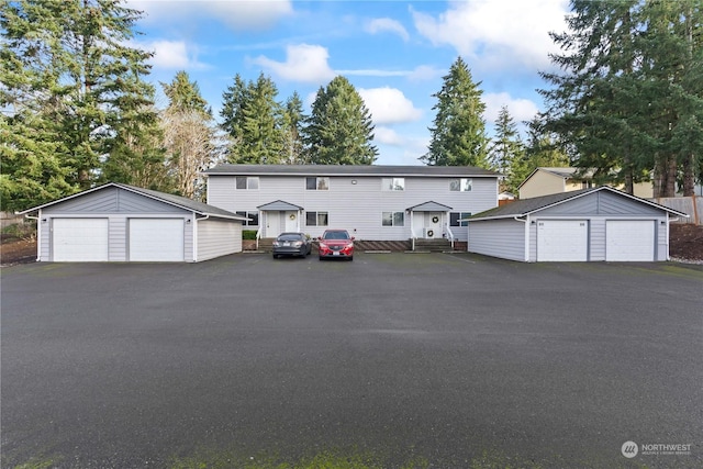 view of front of home featuring a garage and an outbuilding