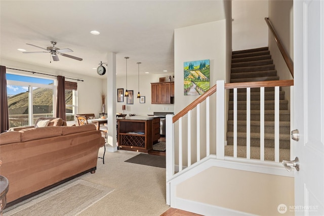 foyer entrance featuring light carpet, ceiling fan, stairway, and recessed lighting