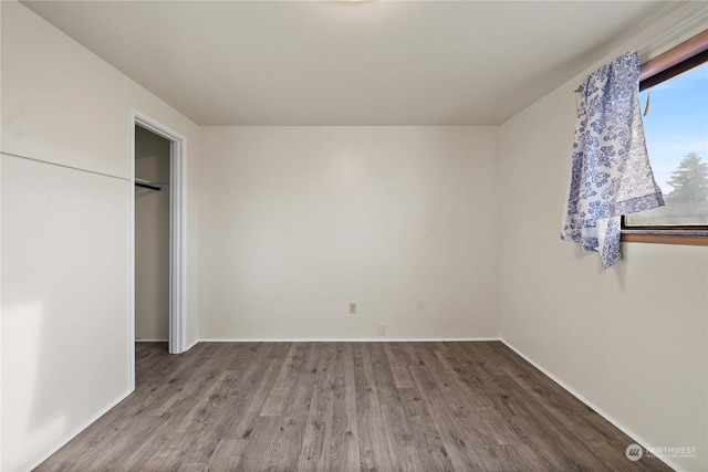 unfurnished bedroom featuring a closet and hardwood / wood-style floors