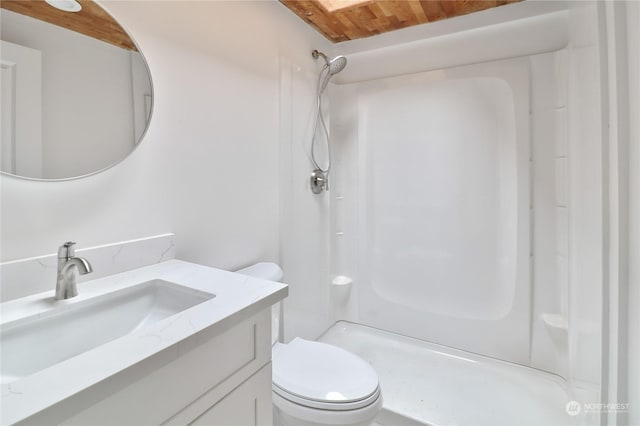 bathroom featuring a shower, toilet, and vanity