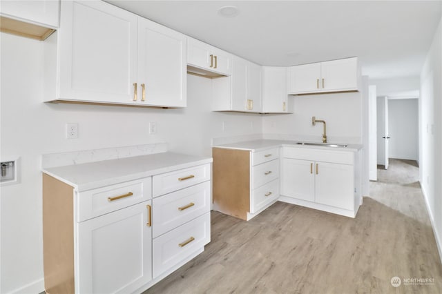 kitchen with sink, white cabinetry, and light hardwood / wood-style floors