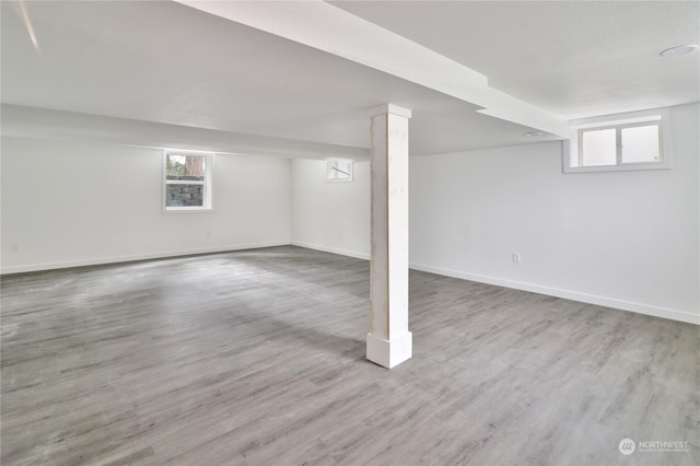 basement with a healthy amount of sunlight and light hardwood / wood-style floors