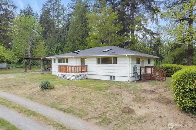 view of front of house with a carport, a wooden deck, a front lawn, and roof with shingles