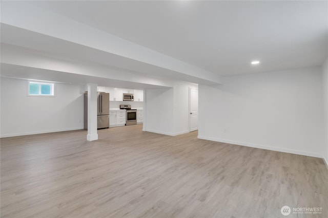 below grade area with high end fridge, baseboards, light wood-type flooring, and recessed lighting