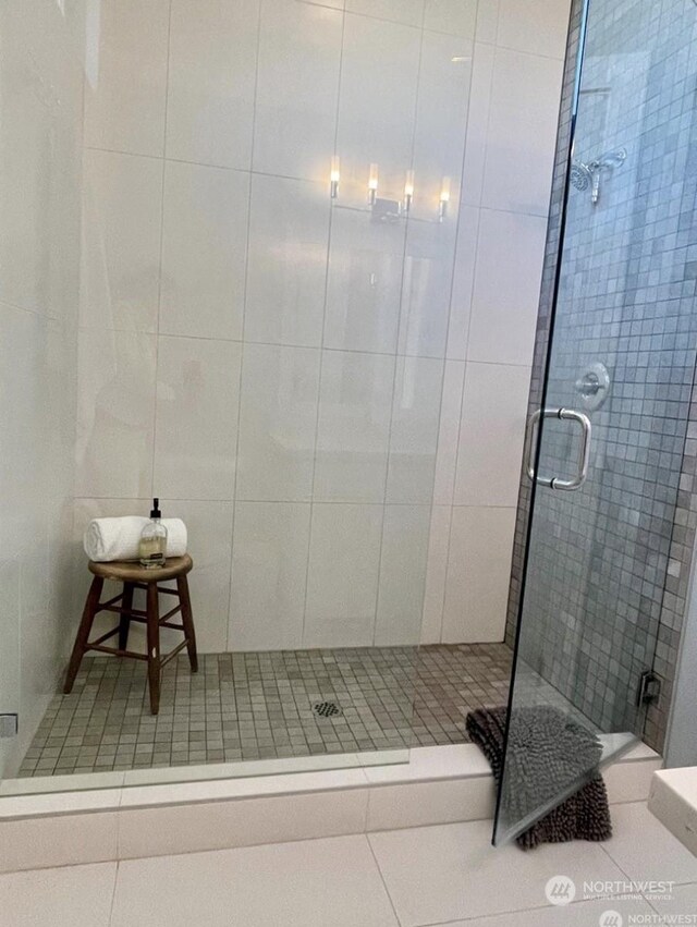 bathroom with tile patterned floors and a shower with door