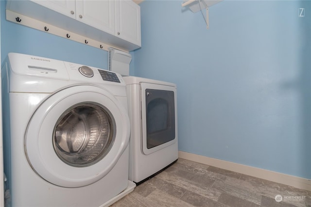 laundry room with washing machine and dryer and cabinets