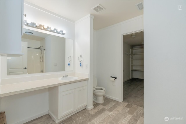 bathroom featuring vanity, toilet, walk in shower, and ornamental molding