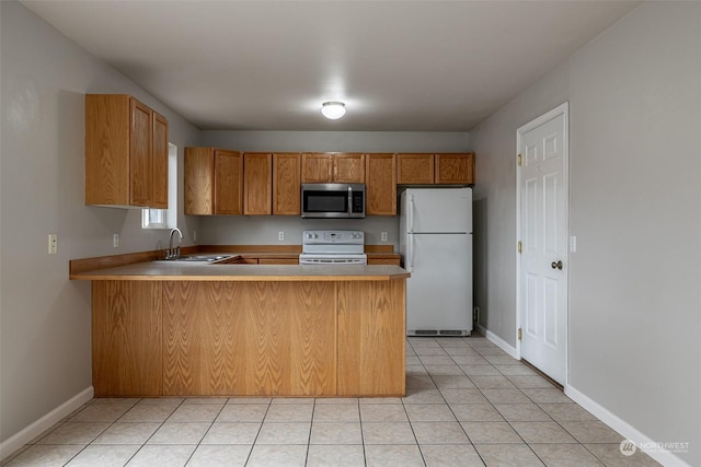 kitchen with kitchen peninsula, light tile patterned floors, white appliances, and sink