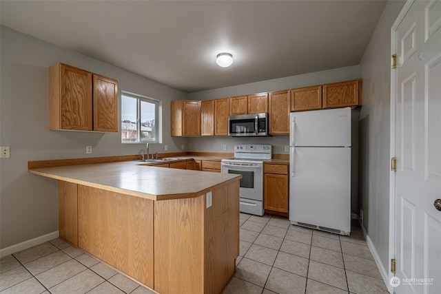 kitchen with kitchen peninsula, light tile patterned floors, white appliances, and sink