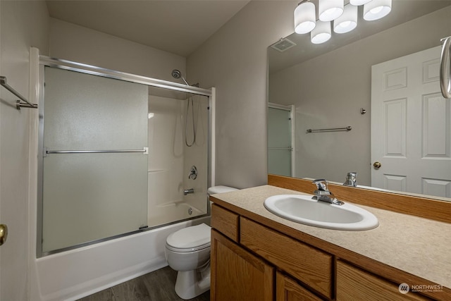 full bathroom with enclosed tub / shower combo, toilet, wood-type flooring, and vanity