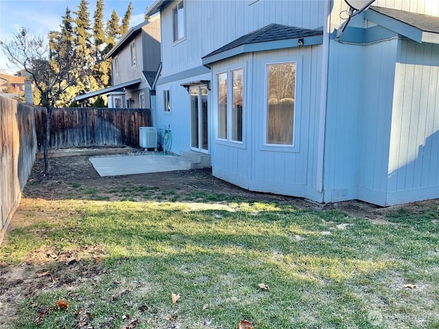 view of home's exterior featuring a fenced backyard, a shingled roof, central AC, and a yard