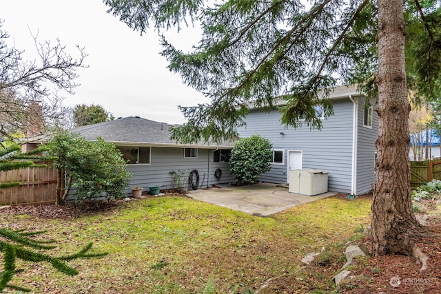 back of house with a yard and a patio