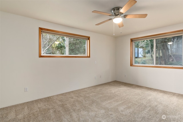 carpeted spare room featuring ceiling fan