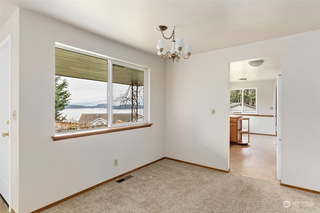 unfurnished room featuring carpet and a chandelier