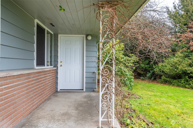 view of exterior entry with a lawn