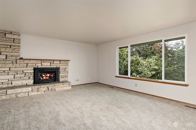 unfurnished living room with carpet and a stone fireplace