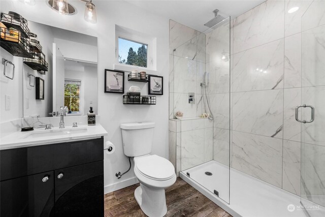 bathroom with hardwood / wood-style flooring, toilet, an enclosed shower, and a healthy amount of sunlight