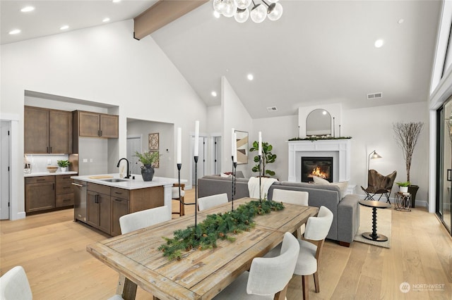 71 Plateau Loop, Cle Elum, WA 98922 - dining space featuring high vaulted ceiling, beamed ceiling, light wood-type flooring, a chandelier, and a glass covered fireplace