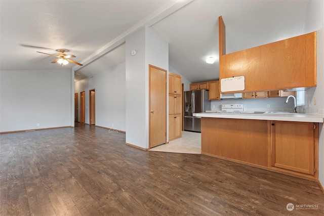 kitchen with ceiling fan, sink, kitchen peninsula, stainless steel fridge, and lofted ceiling