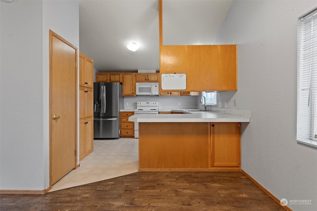 kitchen featuring kitchen peninsula, white appliances, light hardwood / wood-style flooring, and sink