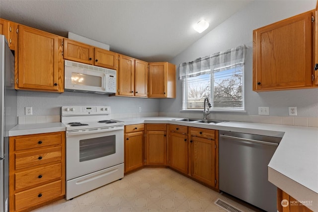 kitchen featuring appliances with stainless steel finishes, lofted ceiling, and sink