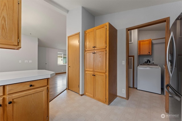 kitchen with stainless steel fridge and washer / dryer