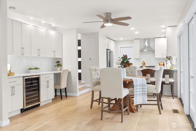 dining room featuring wine cooler, ceiling fan, and light hardwood / wood-style floors