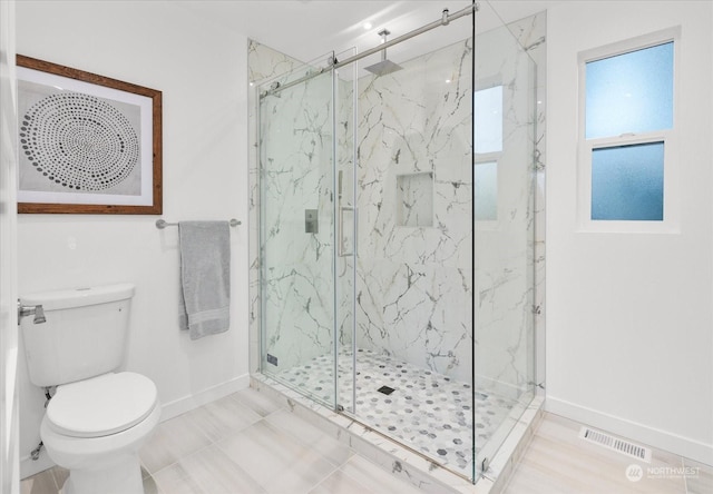 bathroom featuring tile patterned flooring, toilet, and walk in shower