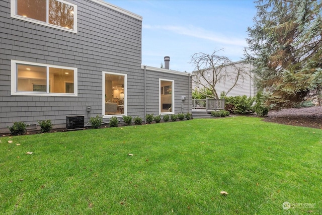 view of yard featuring a deck and central air condition unit