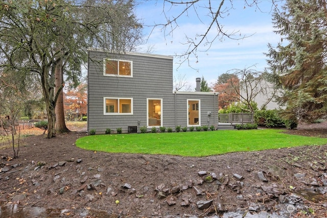 rear view of property with a lawn, central AC unit, and a wooden deck