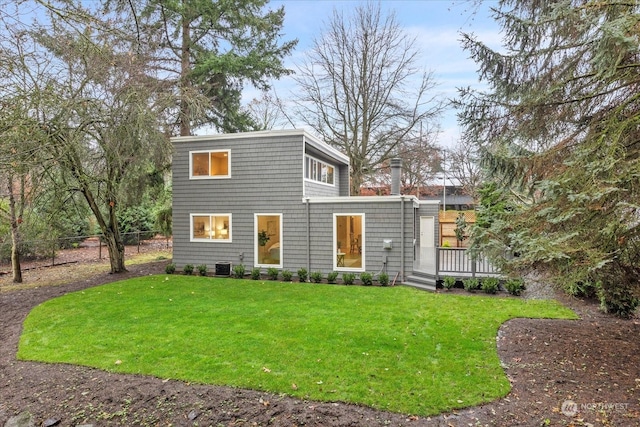 view of front of home featuring central AC unit, a front yard, and a deck