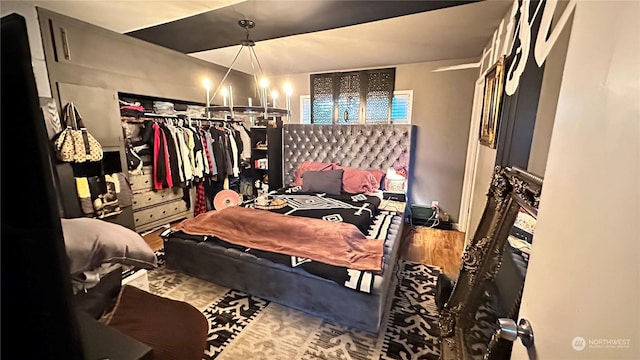 bedroom with hardwood / wood-style floors and a notable chandelier