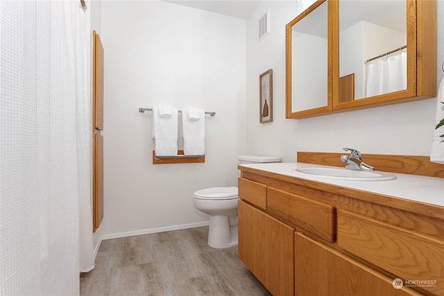 bathroom with vanity, hardwood / wood-style flooring, and toilet