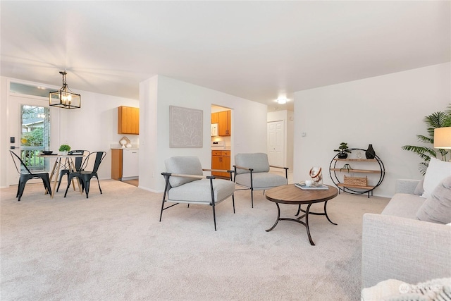 living room featuring light carpet and a notable chandelier